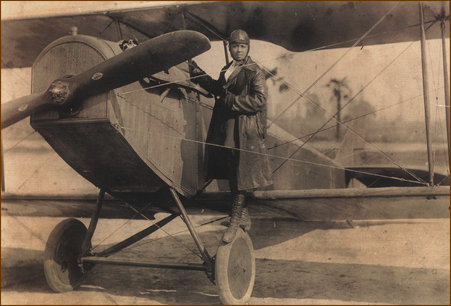 Bessie Coleman with the Curtiss JN-4 biplane she used in her barnstorming air shot appearances across the country.
